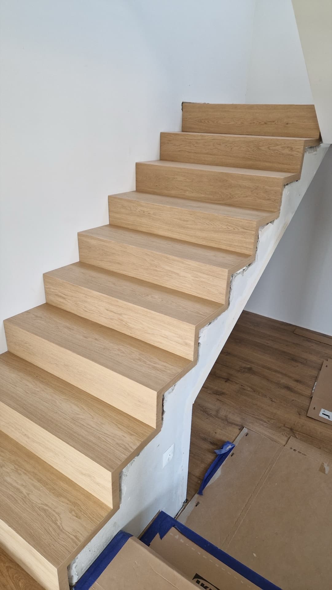 Precyzyjnie wypoziomowane stopnie drewniane na schodach betonowych